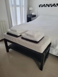 three towels are stacked on a bed in a bedroom at Apartamento Ejecutivo Premium Riviera Tower in Villa Carlos Paz +23 photos