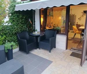 a patio with chairs and a table and an umbrella at Apartman Marija in Barban