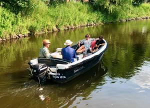 een groep mensen in een kleine boot op een rivier bij Knuffelkamer über der Gracht in Friedrichstadt +24 foto's