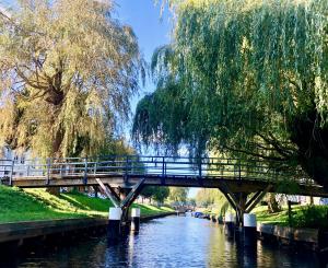 een brug over een rivier in een park bij Knuffelkamer über der Gracht in Friedrichstadt