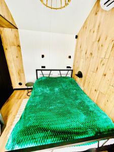 een groot groen bed in een kamer met een tafel bij Domek Jak z Obrazka in Sierpnica +29 foto's