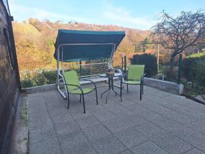 een patio met 2 stoelen en een tafel met een blauwe baldakijn bij Hiža Bake Veronike in Hrašćina