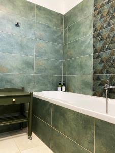 a bathroom with a tub and two bottles of wine at Rizling Vendégház in Balatonrendes