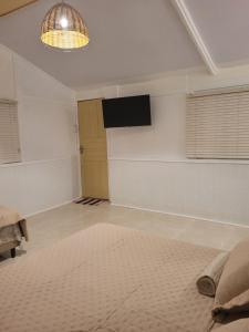 a living room with a television and a room with a rug at Suíte Cambucá in Praia do Bananal