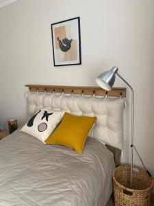 a bedroom with a bed with a white headboard at Rizling Vendégház in Balatonrendes