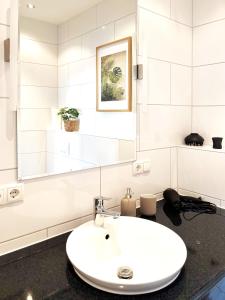 a white bathroom with a sink and a mirror at COZEE - The Oasis in Kaiserslautern +37 photos
