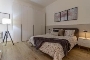 ein weißes Schlafzimmer mit einem Bett und einem Dreibettzimmer in der Unterkunft Loft Altobelli in Rieti