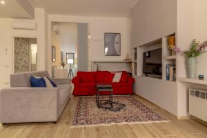 ein Wohnzimmer mit einem roten Sofa und einem Tisch in der Unterkunft Loft Altobelli in Rieti