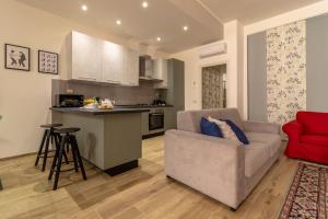 ein Wohnzimmer mit Sofa und eine Küche in der Unterkunft Loft Altobelli in Rieti