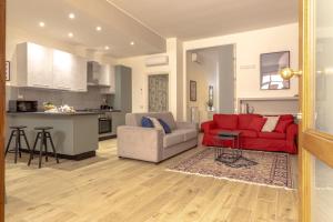 ein Wohnzimmer mit einem roten Sofa und eine Küche in der Unterkunft Loft Altobelli in Rieti