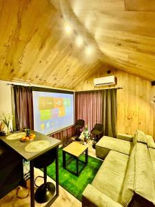 een woonkamer met een bank en een groot scherm bij Domek Jak z Obrazka in Sierpnica