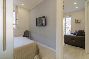 a bedroom with a bed and a couch and a tv on a wall at Residenza Aloe in Boario Terme