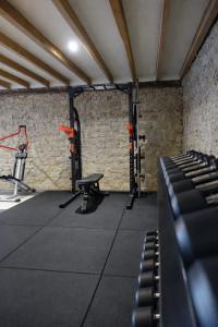 a room with a gym with a bench and equipment at Le Cœur d'Estourgie in Pionsat