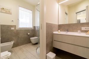 a bathroom with a sink and a toilet at Residenza Aloe in Boario Terme +8 photos