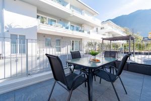 a patio with a table and chairs on a balcony at Residenza Aloe in Boario Terme