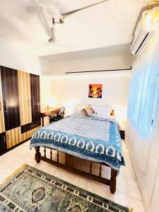 een slaapkamer met een bed met een blauw dekbed bij White House Stay in Patnem