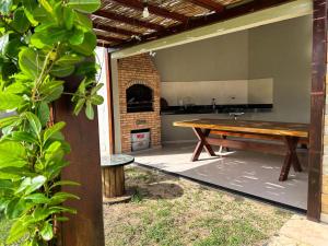 eine Terrasse mit Holztisch und Kamin in der Unterkunft Pousada Melk Beach in Luis Correia
