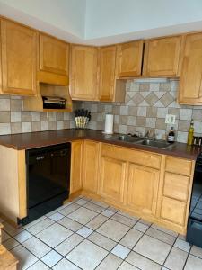 una cucina con armadi in legno e lavastoviglie nera di Jungle House Luxury Stays - Columbus Downtown Short North a Columbus Altre 22 foto