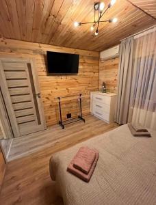a bedroom with a bed and a flat screen tv at mountain house in Skhidnitsa