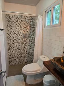 a bathroom with a toilet and a shower at Hotel Zelen in Tamanique +69 photos