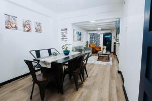 a dining room and living room with a table and chairs at Aintree Bungalow in Portmore
