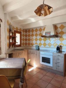 a kitchen with a table and a stove top oven at Casa Escola in La Pobla de Segur