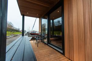 a wooden deck with a bench and windows on a boat at Tiny Boat House #6 in Garnwerd