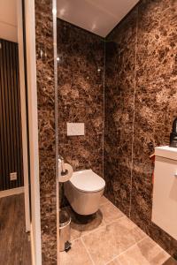 a bathroom with a toilet and a shower at Tiny Boat House #6 in Garnwerd +12 photos