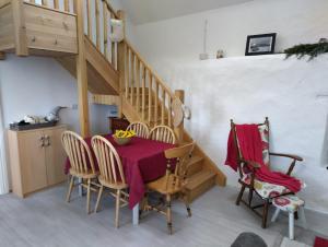 a dining room with a table and chairs and a staircase at Lavender lane cottage in Tralee