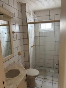 a bathroom with a toilet and a sink at Vista para o molhe in Itapema +15 photos
