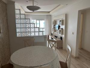 a kitchen and dining room with a table and a table and chairs at Vista para o molhe in Itapema