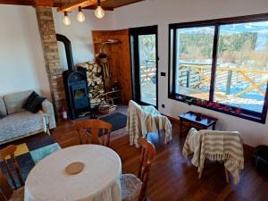 a living room with a table and chairs and a large window at Sunset Mountains Village in Dealu Negru
