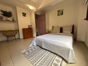 a bedroom with a large bed and a chair at Villa Corail Les Abymes in Les Abymes +30 photos