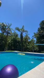 a swimming pool with a purple ball in the water at Morada Amor & Cura Xamanismo in Mongaguá