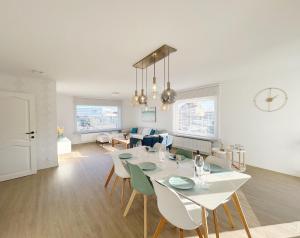 a dining room and living room with a table and chairs at Villa Duin 33 in Westende