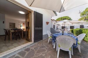 a table with chairs and an umbrella on a patio at Baia Azzurra in Capoliveri