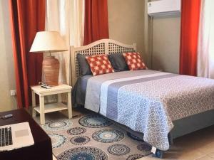 a bedroom with a bed and a table with a laptop at Ocean Grace - Canouan Island in Canouan