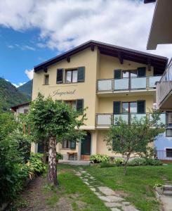 un edificio con un albero di fronte di Imperial Rooms a Grosotto