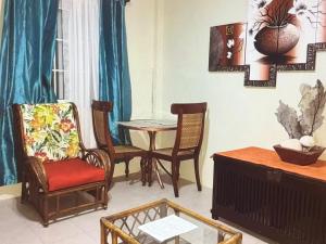 a living room with chairs and a table at Ocean Grace - Canouan Island in Canouan +2 photos