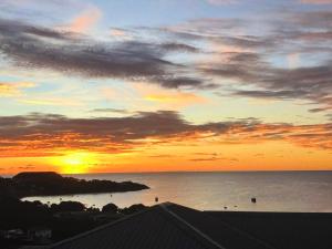 a sunset over a body of water with the ocean at Ocean Grace - Canouan Island in Canouan