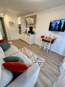 a living room with a couch and a table at Studio Cosy et élégant avec Terrasse in Caluire-et-Cuire