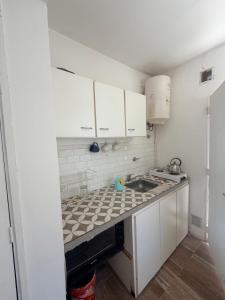 a small kitchen with white cabinets and a sink at Terminal Depto in Azul