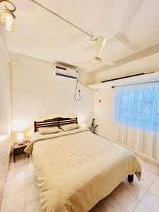 een slaapkamer met een bed en een raam bij White House Stay in Patnem