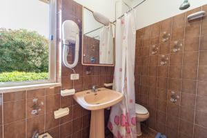 a bathroom with a sink and a toilet and a mirror at Baia Azzurra in Capoliveri +61 photos