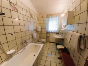 un bagno con vasca, WC e lavandino di Imperial Rooms a Grosotto