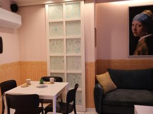 a living room with a table and a portrait of a woman at Maison Prestige in Monfalcone