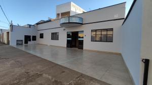 a white building with a balcony on top of it at Hotel Mirian in Patos de Minas