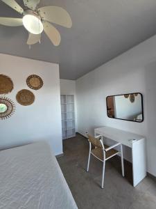a bedroom with a bed and a desk and a mirror at Hotel Zelen in Tamanique