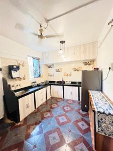 een keuken met een tegelvloer en een koelkast bij White House Stay in Patnem