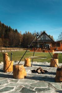 a swing set in a park with logs at Muciówka in Jurków